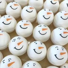 Charger l'image dans la galerie, Plusieurs bombes de bain bonhomme de neige sont entrain de sécher dans un plateau de séchage. Elles sont peintes à la main d'un mignon visage de bonhomme de neige.