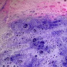 Charger l'image dans la galerie, On voit une belle mousse de bombes de bain rose et mauve dans l'eau du bain.