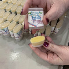 Charger l'image dans la galerie, Une personne tient un tube de baume petit jouffle ouvert pour montrer sa belle texture lisse.