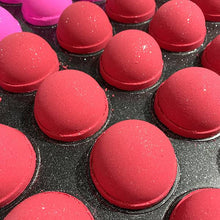 Charger l'image dans la galerie, Plusieurs bombes de bain rouges à la canneberge sont entrain de sécher dans un plateau de production.