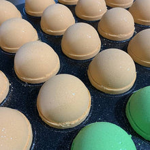 Charger l'image dans la galerie, Plusieurs bombes de bain de couleur orangées sont entrain de sécher dans un plateau de production.