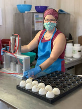 Charger l'image dans la galerie, En production des bombes de bain Avoine nature, une femme est entrain de presser des bombes de bain à l'aide d'une presse pneumatique.