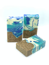 Charger l'image dans la galerie, Savons de fantaisie faits à la main. Décoré d'un joli motif marbré avec des couleurs blanche, bleue turquoise et brun. La partie brune à des petit grains de café moulus. Une estampe de la forme des Îles-de-la-Madeleine apparaît sur chaque savon.