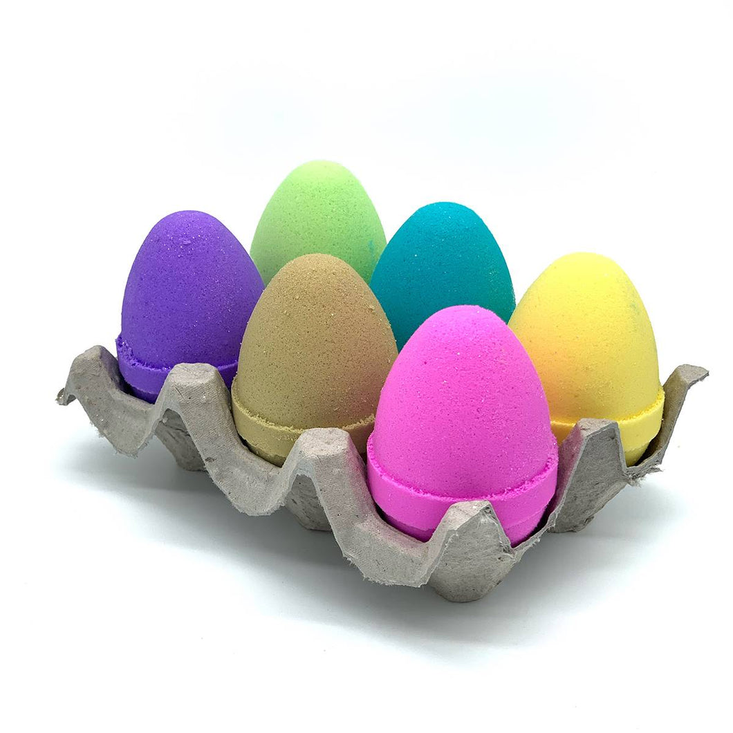Bombes de bain en forme d'oeufs de Pâques aux couleurs arc-en-ciel. Ils sont présentés dans une petite boîte d'oeufs cartonnée.