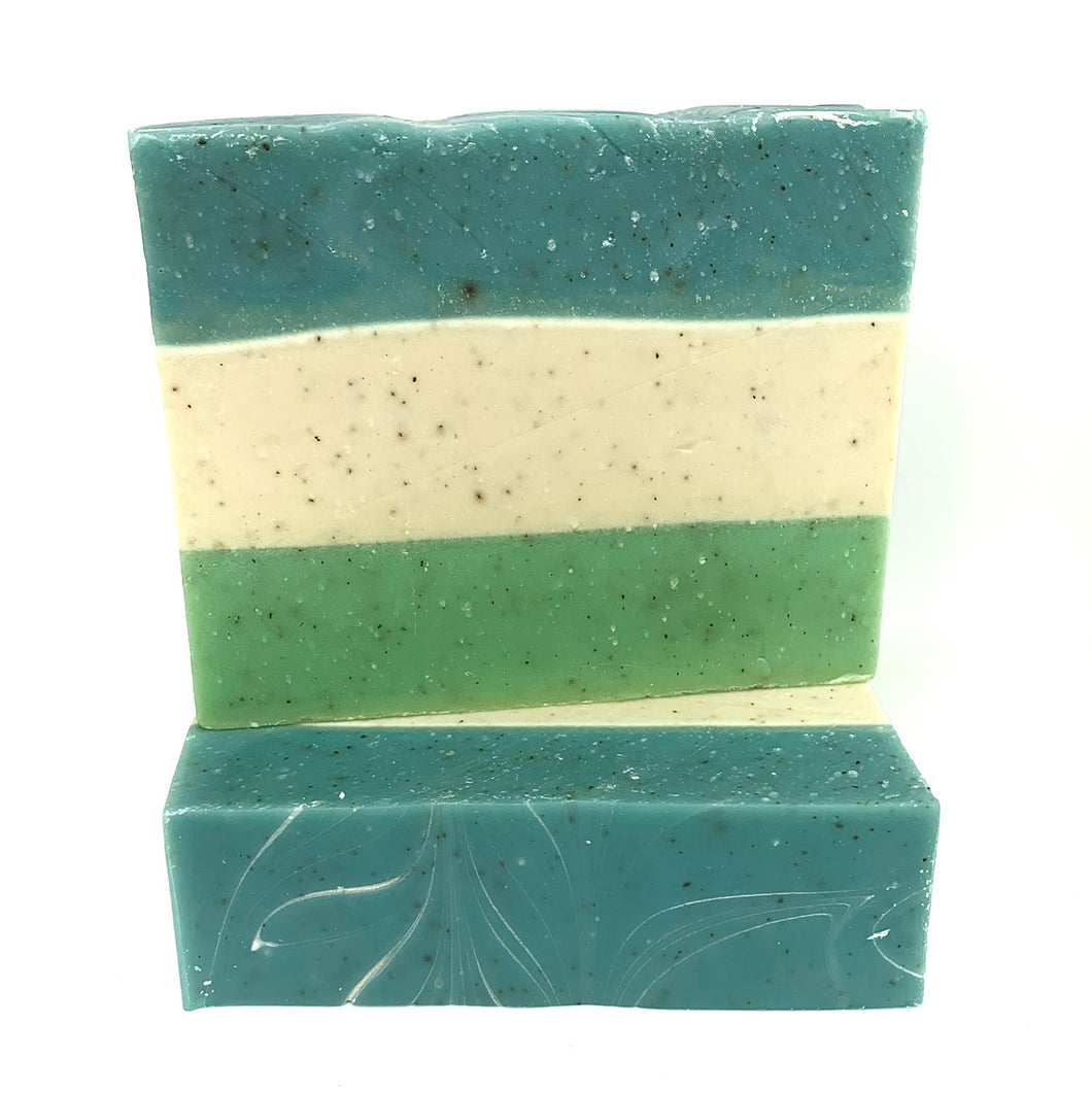 Savon de fantaisie fait à la main. Motif de couleurs superposée de vert, blanc et bleu. On voit la texture de la pierre ponce dans le savon.