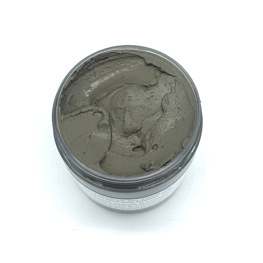 Un pot remplis de bain de boue minérale de couleur grise. La photo est prise sur fond blanc.